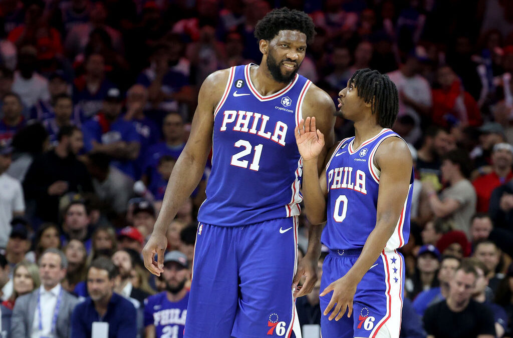 Tyrese Maxey conversa con Joel Embiid durante un partido de los Philadelphia 76ers.