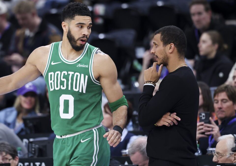 Jayson Tatum conversa con Joe Mazzulla durante un partido de los Celtics.